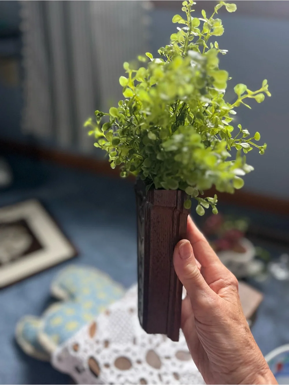 Carved Dark Wood Wall Pocket Vase will include a sprig of greenery